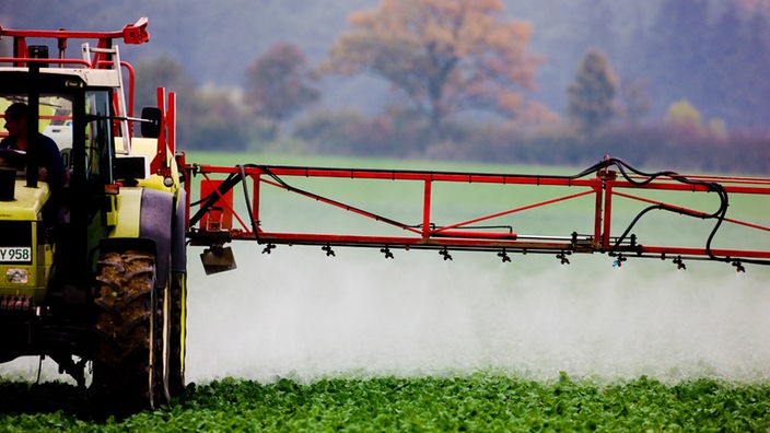 Ein Landwirt versprüht auf einem Feld ein Pestizid