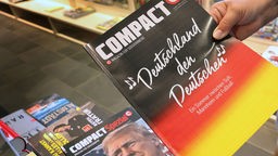 Eine Hand hält eine Ausgabe des Magazins "Compact"in die Kamera, 16.07.2024.