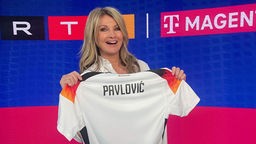 Frauke Ludowig hält in der RTL-Sendung "Exclusiv - Das Starmagazin" ein Trikot mit dem Namen Pavlovic.