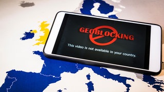 Smartphone mit Geoblocking  liegt über EU-Karte.