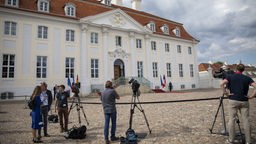 Journalisten stehen vor Schloss Meseberg und warten auf einen Interviewgast. 