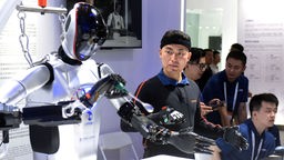 Mitarbeiter demonstriert einen gestengesteuerten Roboter während der Welt-KI-Konferenz 2024 in Shanghai, Ostchina, 04.07.2024.