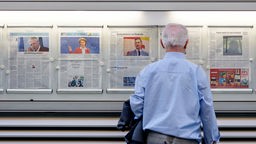 Ein Leser studiert die Schlagzeilen am Aushangkasten der Kölnischen Rundschau. 