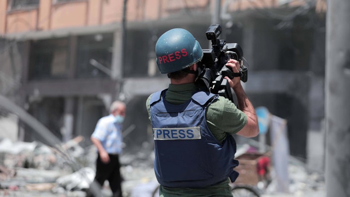 Symbolbild aus Gaza 2021: Ein palästinensischer Journalist dokumentiert die Trümmer des schwer beschädigten Al-Jawhara-Turms in Gaza-Stadt. 