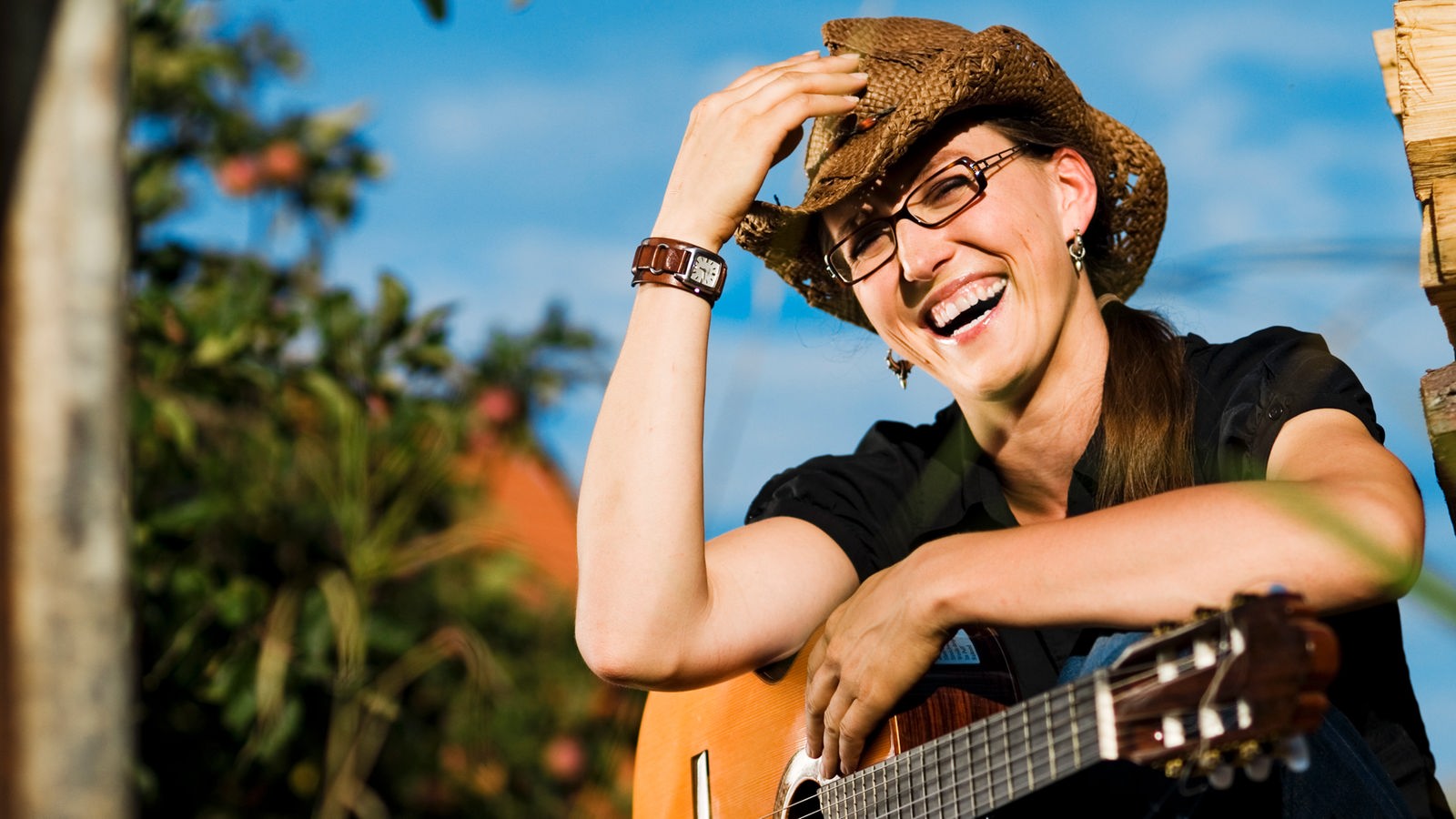 Martina Schwarzmann mit Hut und Gitarre