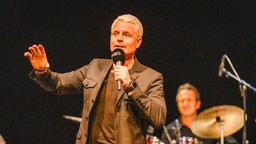 Guido Cantz mit Mikrofon auf der Bühne beim Zeltfestival Ruhr