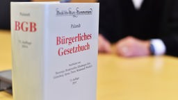  An der Richterbank eines Sitzungssaals beim Oberlandesgericht (OLG) Karlsruhe (Baden-Württemberg) sitzt am 12.09.2014 ein Richter mit Richterrobe, davor steht ein Bürgerliches Gesetzbuch