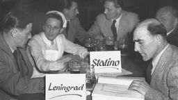 Kriegsgefangene aus den Lagern Stalino und Leningrad geben einer Rotkreuz-Schwester Hinweise zu den Namen Verschollener. Aufnahme aus dem Jahr 1953