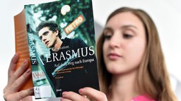 Eine Studentin liest in einem Buch über das Erasmus-Programm