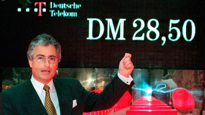 Der damalige Vorstandsvorsitzende der Deutschen Telekom, Ron Sommer, zeigt vor der Deutschen Börse in Frankfurt am Main auf die Anzeigentafel auf der der Erstausgabepreis von 28,50 DM für die Telekom-Aktie zu lesen ist (Archivfoto vom 17.11.1996). 