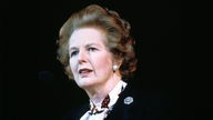 Margaret Thatcher im Porträt - sie schaut mit perfekt frisierten Haaren ernst zur Seite, der Hintergrund ist schwarz, Aufnahme von 1980