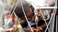 Ein Junge aus dem Kongo trinkt in Bunia im Flüchtlingslager gereinigtes Trinkwasser