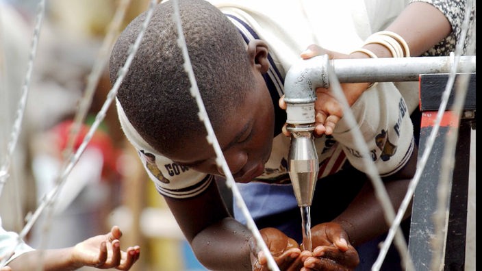 Ein Junge aus dem Kongo trinkt in Bunia im Flüchtlingslager gereinigtes Trinkwasser
