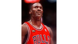 Ein Mann mit Glatze im roten Trikot und der Aufschrift "Bulls" schaut stolz nach oben, Schweiß bedeckt seine dunkle Haut