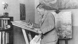 Der Bühnenbildner Caspar Neher steht in seinem Studio und malt. Aufnahme Anfang 1930er Jahre