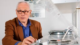 Dieter Rams, früherer Designer vieler Braun-Geräte, betätigt in Kronberg im Taunus in der BraunSammlung ein Tonbandgerät von Braun.