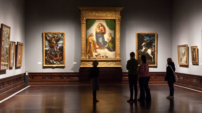 Saal der Staatlichen Kunstsammlung in Dresden. Besucher schauen auf "Sixtinnische Madonna"