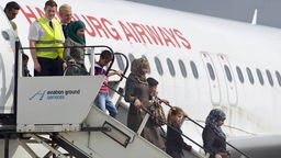 Syrische Frauen und Kinder steigen in Hannover aus dem Flugzeug