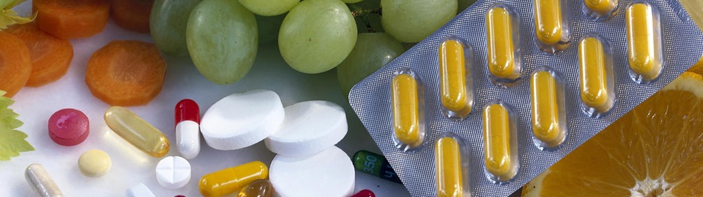Vitamine in verschiedener Form: Als Tabletten und in Obst und Gemüse