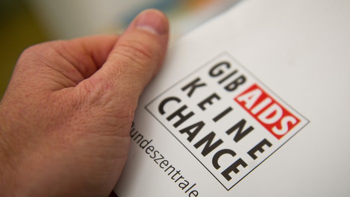 Eine Hand hält am 30.10.2013 in der Münchner Aids-Hilfe e.V. (Bayern) ein Plakat mit der Aufschrift "Gib Aids keine Chance". 