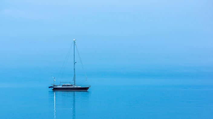 Eine einsame Yacht auf weitem Meer.