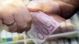 Symbolbild Korruption: Ein 500 Euro-Schein wird übergeben