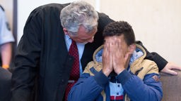 Der 23-jähriger angeklagte Algerier sitzt am 06.05.2016 im Amtsgericht in Köln (Nordrhein-Westfalen) neben seinem Verteidiger Rüdiger Buhr auf der Anklagebank und hält sich die Hand vor das Gesicht. 