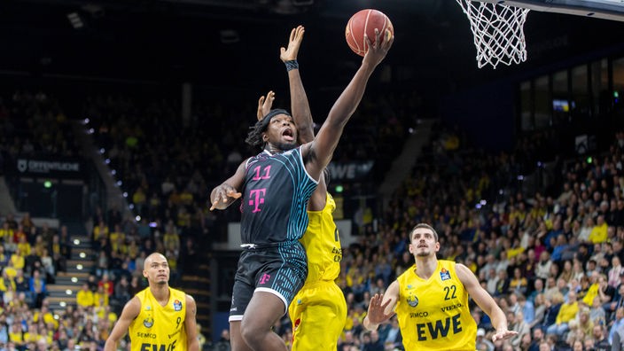 Brian Fobbs (Mitte) von den Baskets Bonn macht im Spiel in Oldenburg einen Korbleger