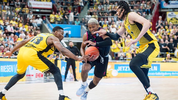 TJ Shorts II (Mitte) von Baskets Bonn im Duell mit Ludwigsburgs Yorman Polas Bartolo (links) und Jonathan Baehre.