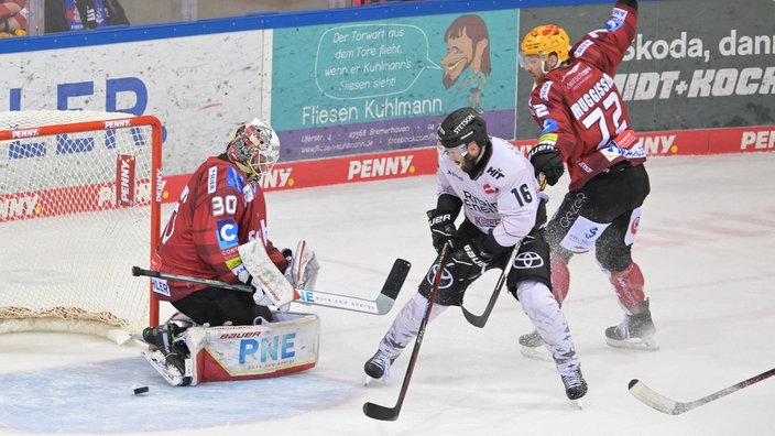 Jason Bast von den Kölner Haien schießt auf das Tor von Kristers Gudlevskis von den Fischtown Pinguins. 