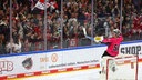 Julius Hidacek, Goalie der Kölner Haie, sitzt auf dem Tor und feiert mit den Fans.