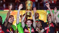 Die Spieler von Bayer Leverkusen feiern nach dem DFB-Pokal-Sieg mit der Trophäe