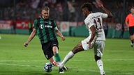 Münsters Marc Lorenz (l) im Kampf um den Ball mit Münchens Kingsley Coman (r).