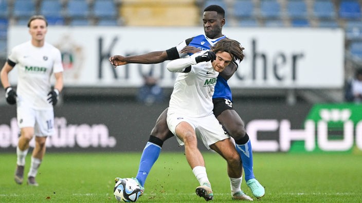 Merveille Biankadi von Arminia Bielefeld (hinten) im Duell mit Tim Danhof von Erzgebirge Aue.