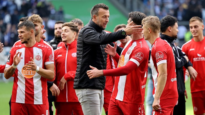 Rot-Weiss Essens Trainer Christoph Dabrowski (m.) freut sich mit seinen Spielern über den Sieg gegen Duisburg.
