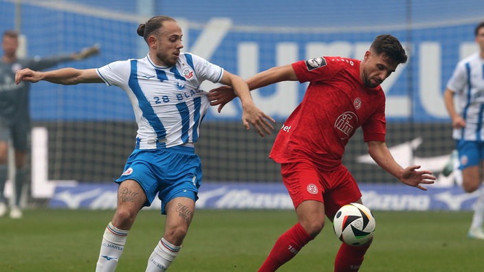 Rostocks Adrien Lebeau (l.) im Duell mit Essens Ahmet Arslan.