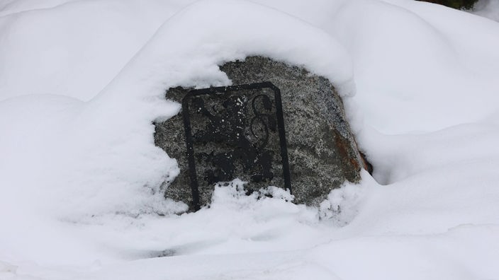 Das Logo des TSV 1860 München am Trainingsgelände unter Schnee begraben
