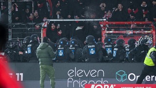 Fans von Rot-Weiss Essen werden im Stadion des VfL Osnabrück von der Polizei zurückgedrängt