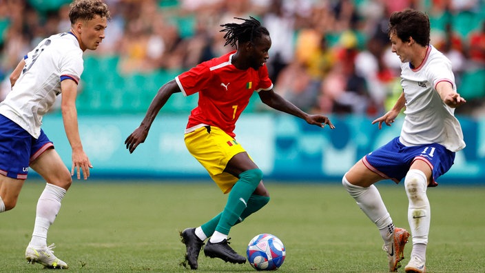 Fußballprofi Aliou Balde (M.) im Trikot von Guniea bei den Olympischen Spielen 2024 in Paris