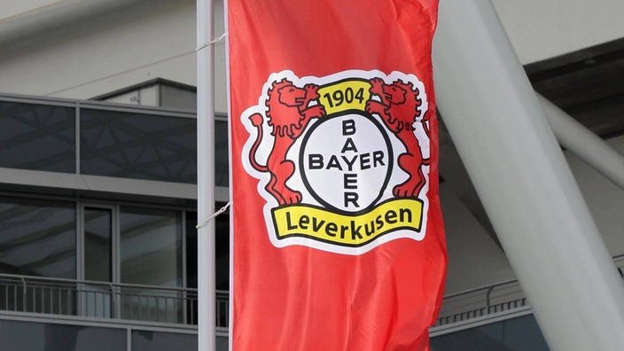 Das Logo von Bayer 04 Leverkusen prangt auf einer Fahne vor dem Stadion