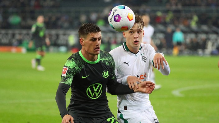 Wolfsburgs Joakim Maehle duelliert sich mit Luca Netz von Borussia Mönchengladbach