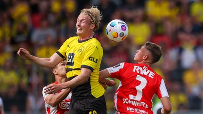 Dortmunds Julian Brandt (M.) im Kopfballduell mit Erfurts Andrey Startsev (l.) und Til Schwarz.