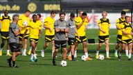 Das Trainergespann um Edin Terzic (in Grau, Mitte) führt die Mannschaft von Borussia Dortmund über den Trainingsplatz