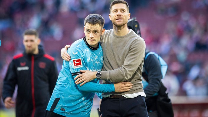 Florian Wirtz (l.) von Bayer 04 Leverkusen und Trainer Xabi Alonso.