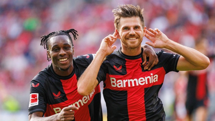 Jeremie Frimpong (l.) von Bayer Leverkusen mit Teamkollege Jonas Hofmann