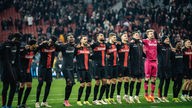 DIe Mannschaft von Bayer 04 Leverkusen feiert vor der Kurve