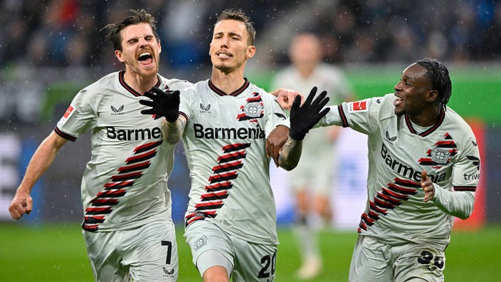 Jonas Hofmann, Alejandro Grimaldo und Jeremie Frimpong feiern das dritte Leverkusener Tor in Hoffenheim.