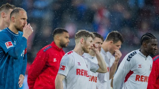 Spieler des 1. FC Köln stehen enttäuscht in Richtung ihrer Fans