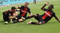 Leverkusens Exequiel Palacios (Mitte) feiert sein Tor gegen Darmstadt mit Granit Xhaka (links) and Jeremie Frimpong.
