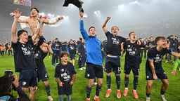 Spieler und Trainer des VfL Bochum feiern nach dem Relegationssieg gegen Fortuna Düsseldorf